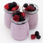 Blueberry panna cotta in small glass jars topped with berries