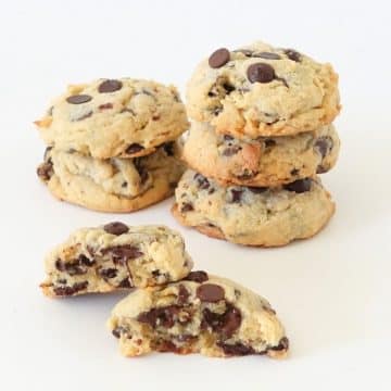 Stack of thick bakery chocolate chip cookies with golden edges and gooey centers