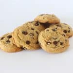 Freshly baked chocolate chip cookies stacked with melty chocolate chips and golden edges
