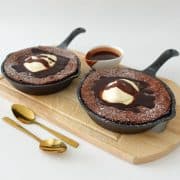 skillet brownie topped with cream and dusted with powdered sugar