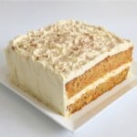 Moist homemade carrot cake topped with cream cheese frosting and sprinkled with cinnamon