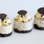 Mini Cookies and Cream Cheesecakes topped with whipped cream and Oreo pieces