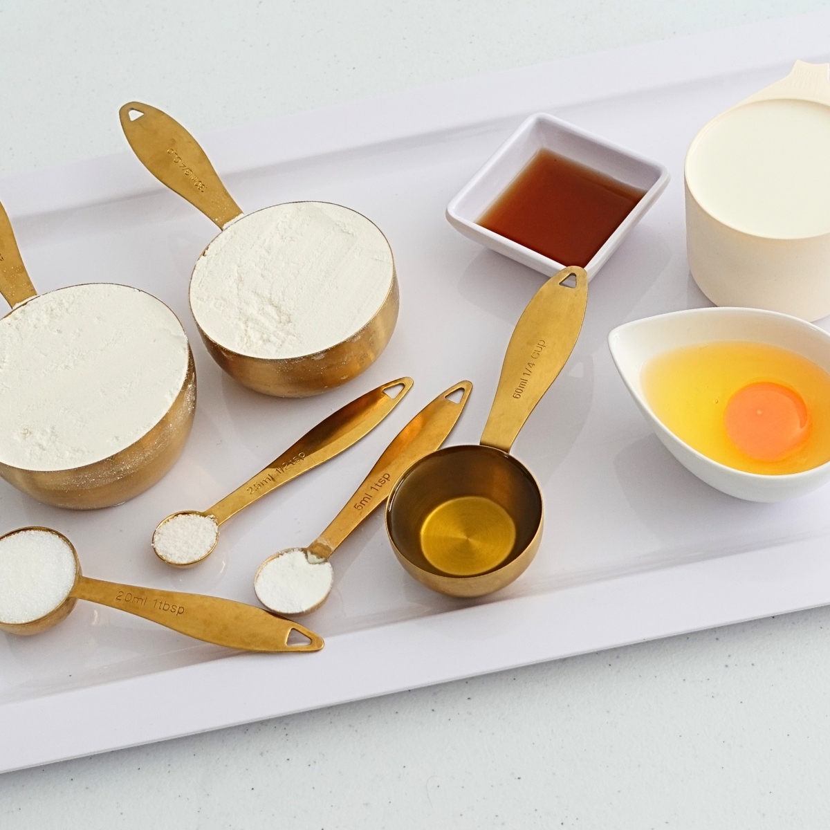 Ingredients for mini waffles including flour, eggs, milk, sugar, and vanilla extract