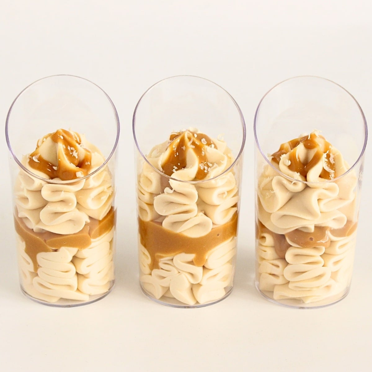 Whipped caramel mousse piped into glass dessert cups