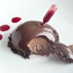 Chocolate Mousse Dome topped with glossy ganache glaze and raspberry garnish