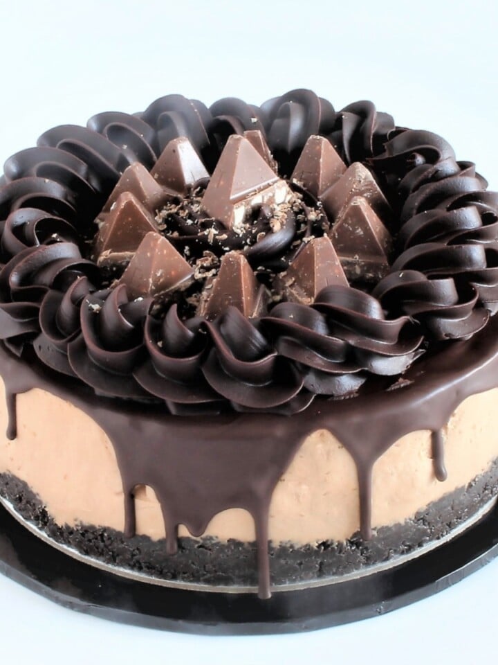 Whole Toblerone cheesecake with chocolate drip, ganache border, and Toblerone pieces on top