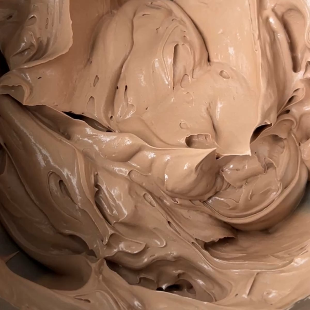 Close up of smooth chocolate buttercream in a mixing bowl