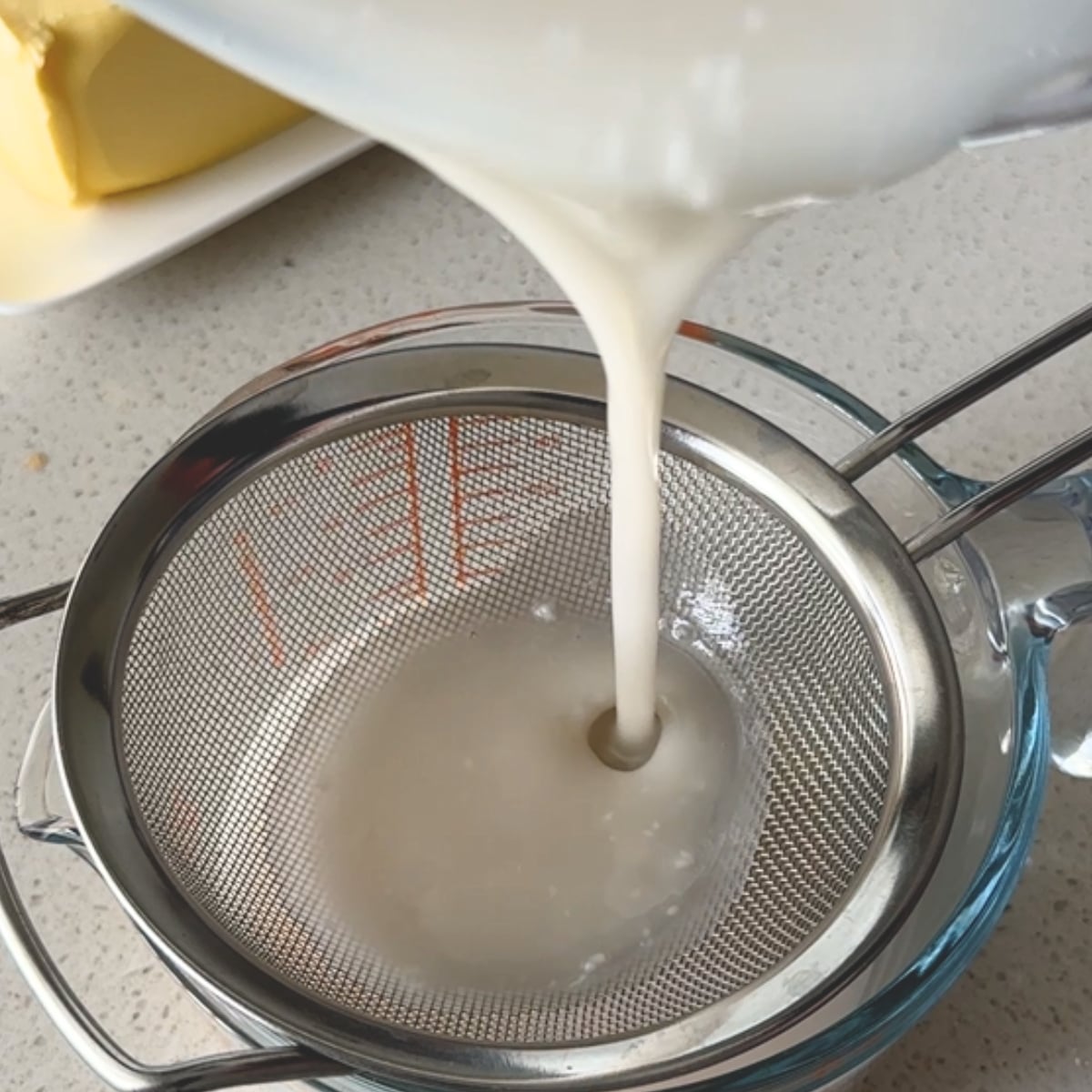 Pouring hot water and sugar mixture through a fine sieve