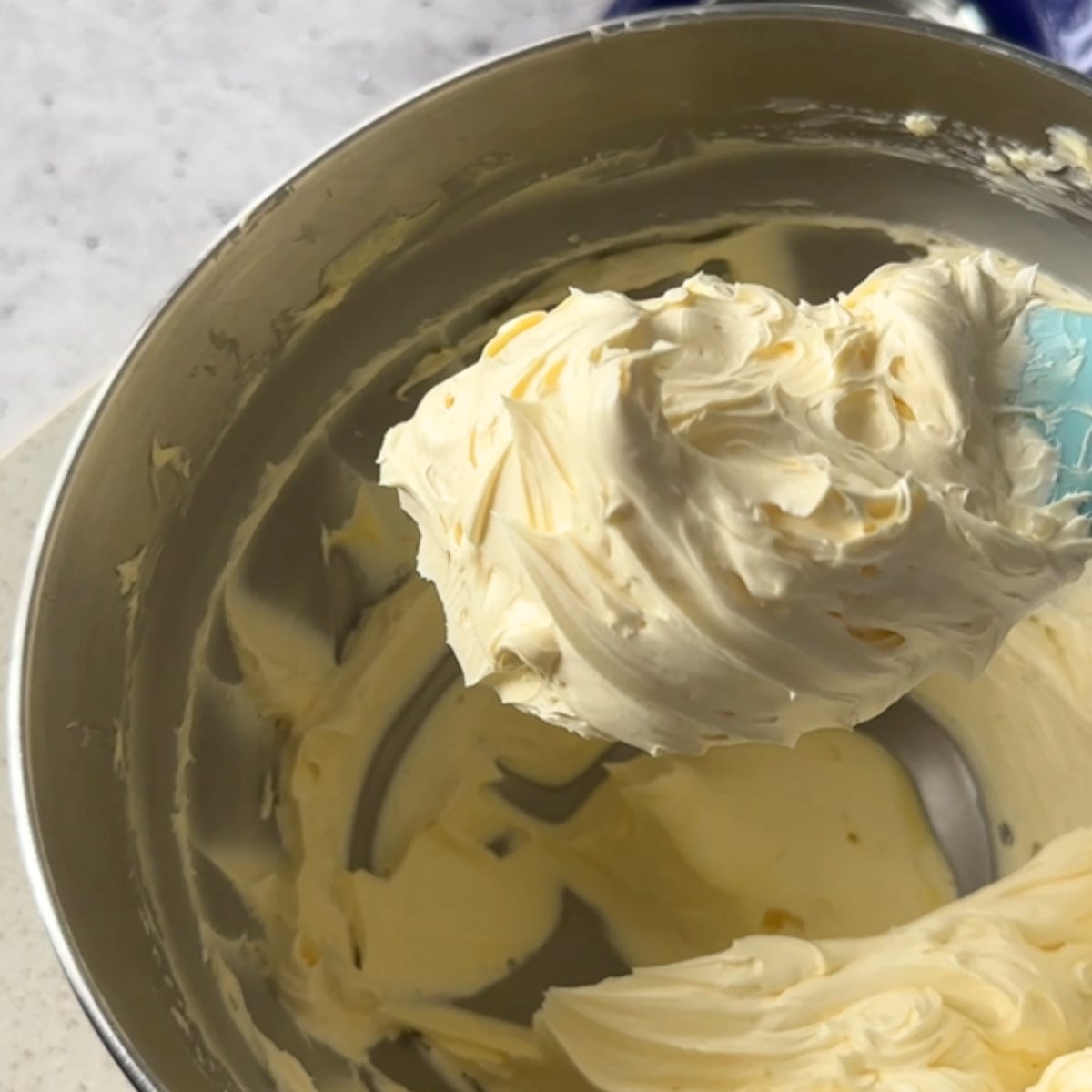 Pale, fluffy whipped butter on a stand mixer paddle
