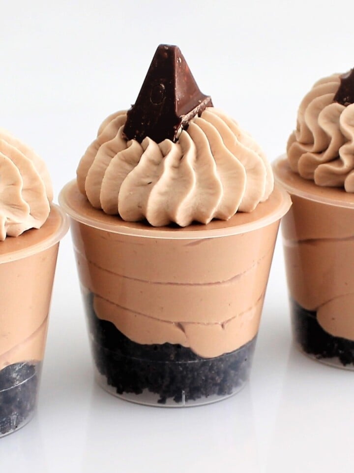 Mini Toblerone dessert cups layered with chocolate cookie base, Toblerone mousse, and piped whipped cream, topped with Toblerone pieces