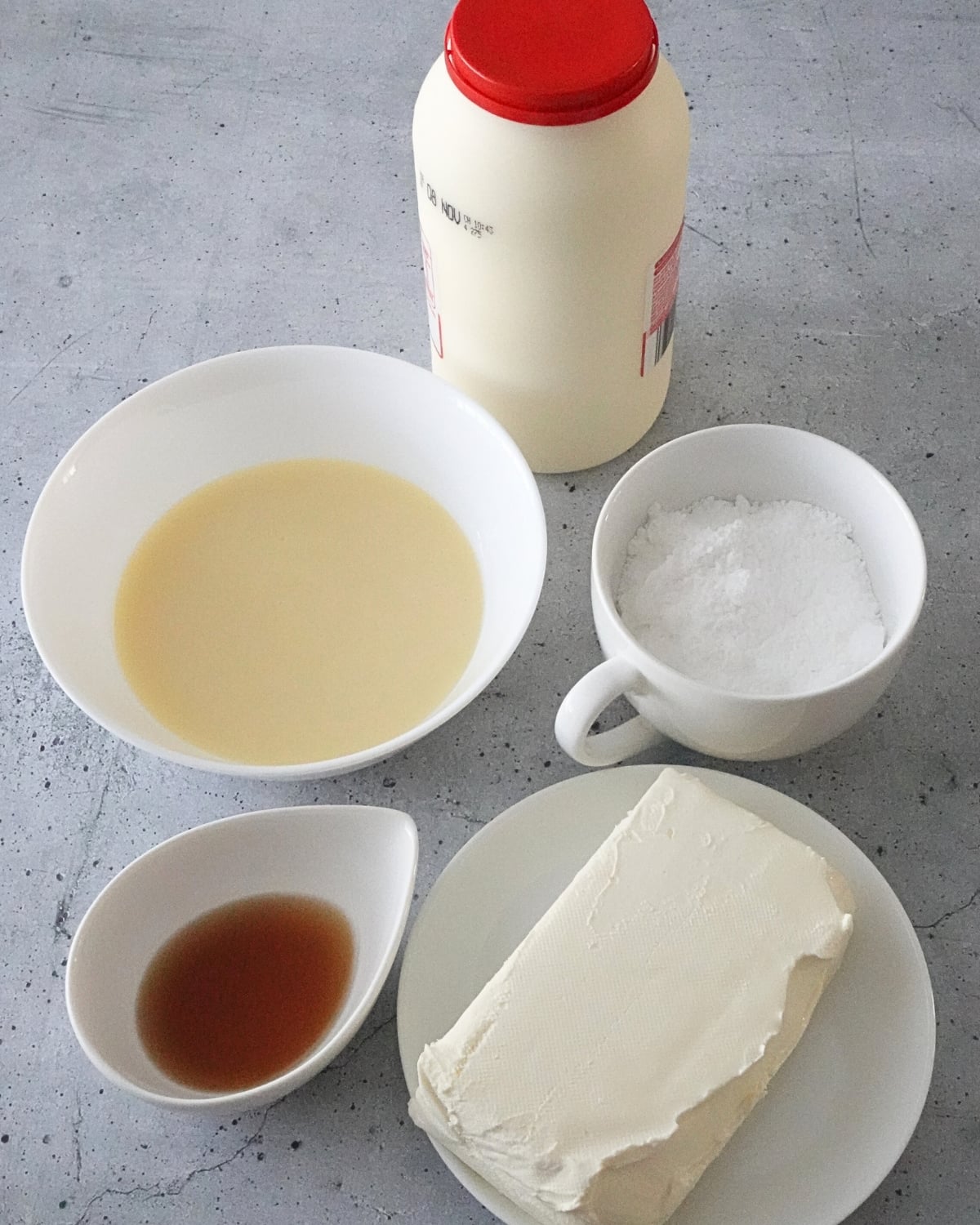 Cream cheese frosting ingredients including cream cheese, sweetened condensed milk, powdered sugar, cream, and vanilla