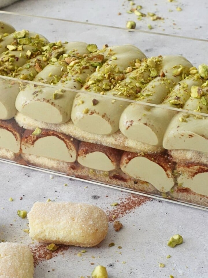 Layered no-bake pistachio tiramisu cheesecake showing layers of ladyfingers and pistachio filling