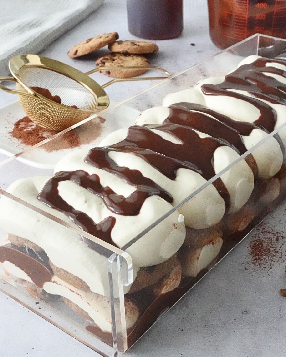 No-bake chocolate chip tiramisu cheesecake filling drizzled with chocolate ganache in a loaf pan