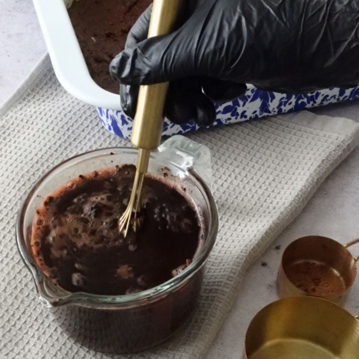Chocolate sauce mixture whisked together in a glass jug