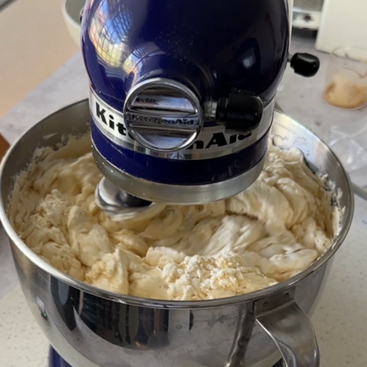 Coffee hot water buttercream mid-mix showing the curdled stage in a stand mixer