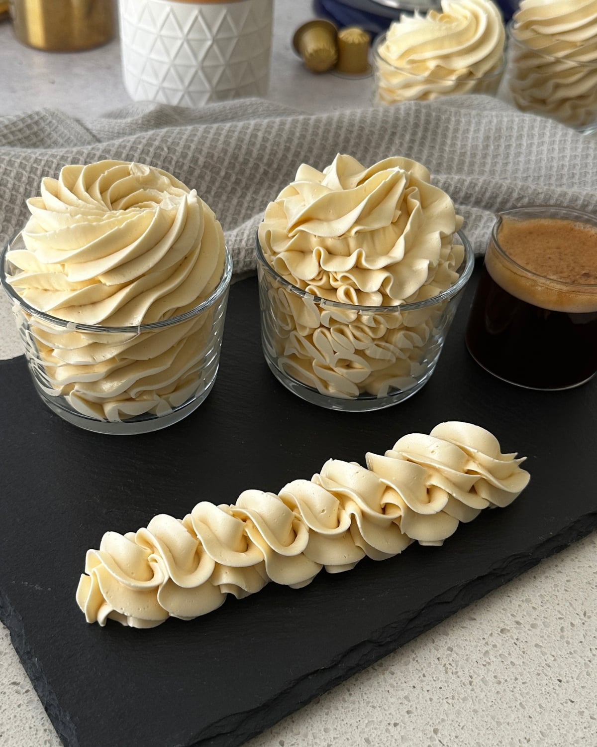 Coffee hot water buttercream piped with a 1M tip and a Jem 3J tip alongside a rope border and brewed espresso