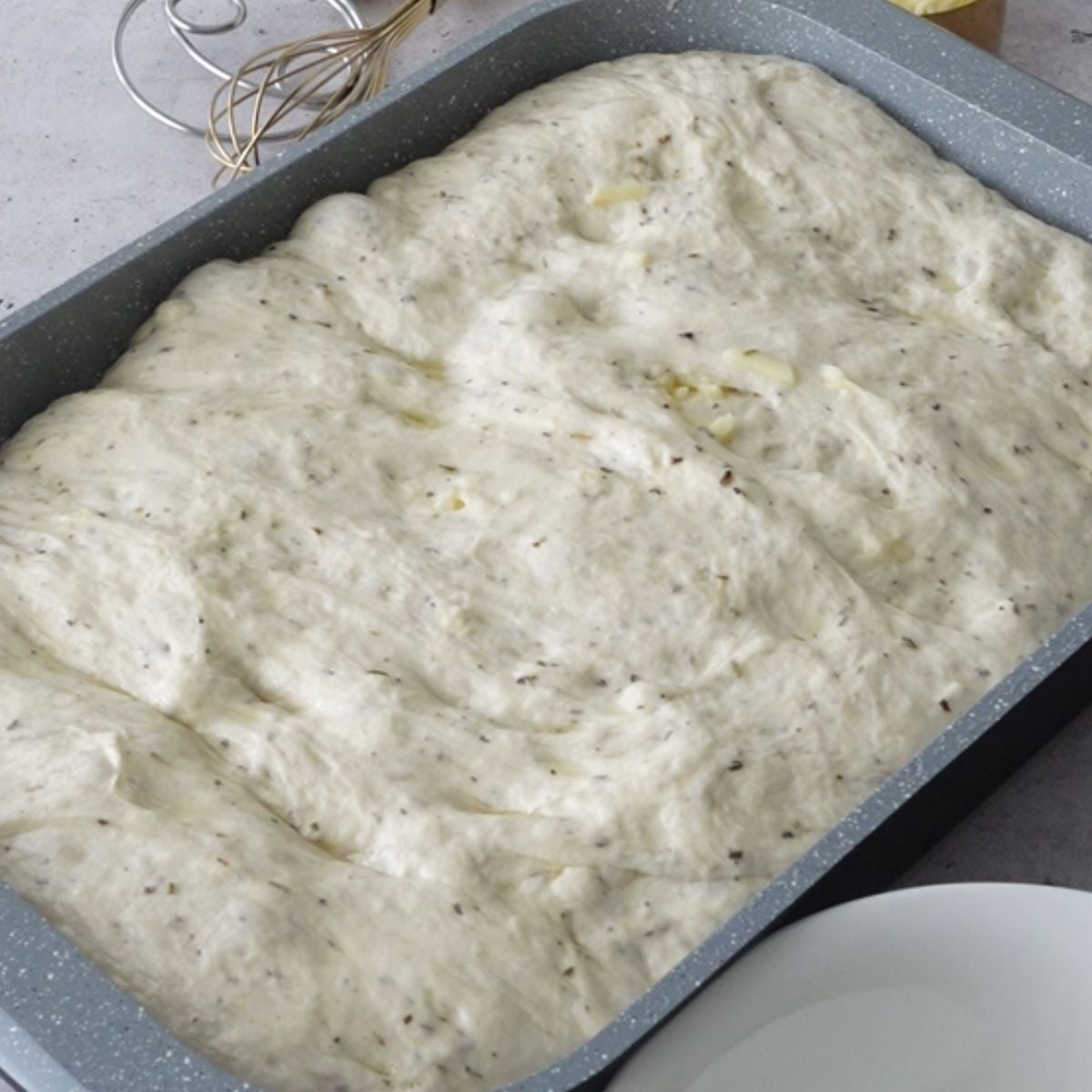 Puffy risen focaccia dough in the pan