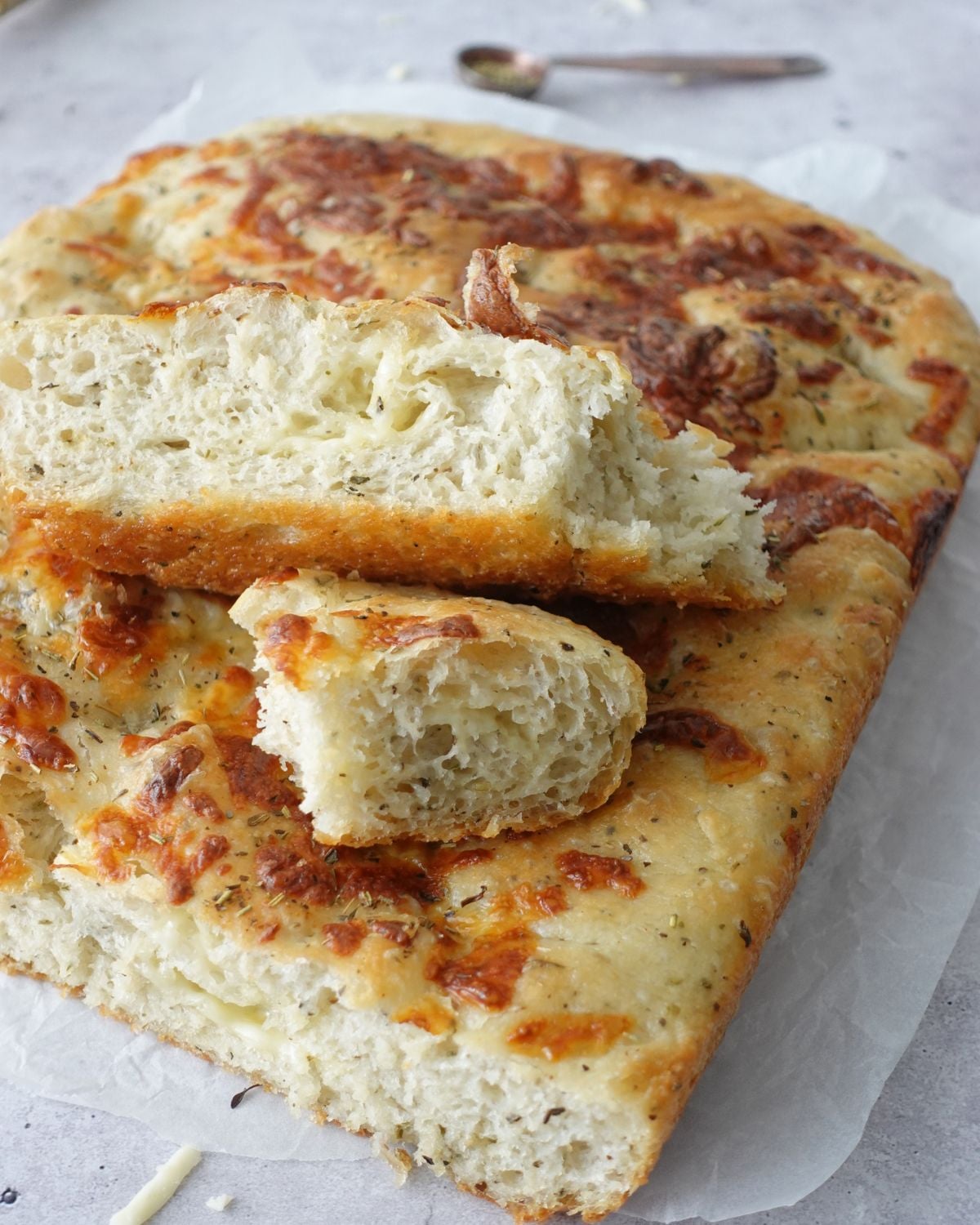Close-up of same-day herb and cheese focaccia with cut pieces turned to show the crumb