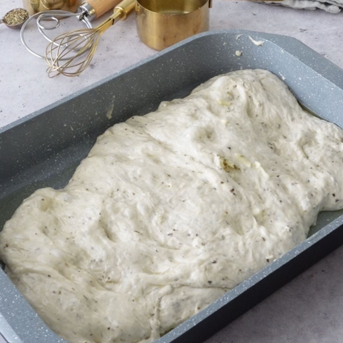 Mozzarella folded into focaccia dough in a baking pan