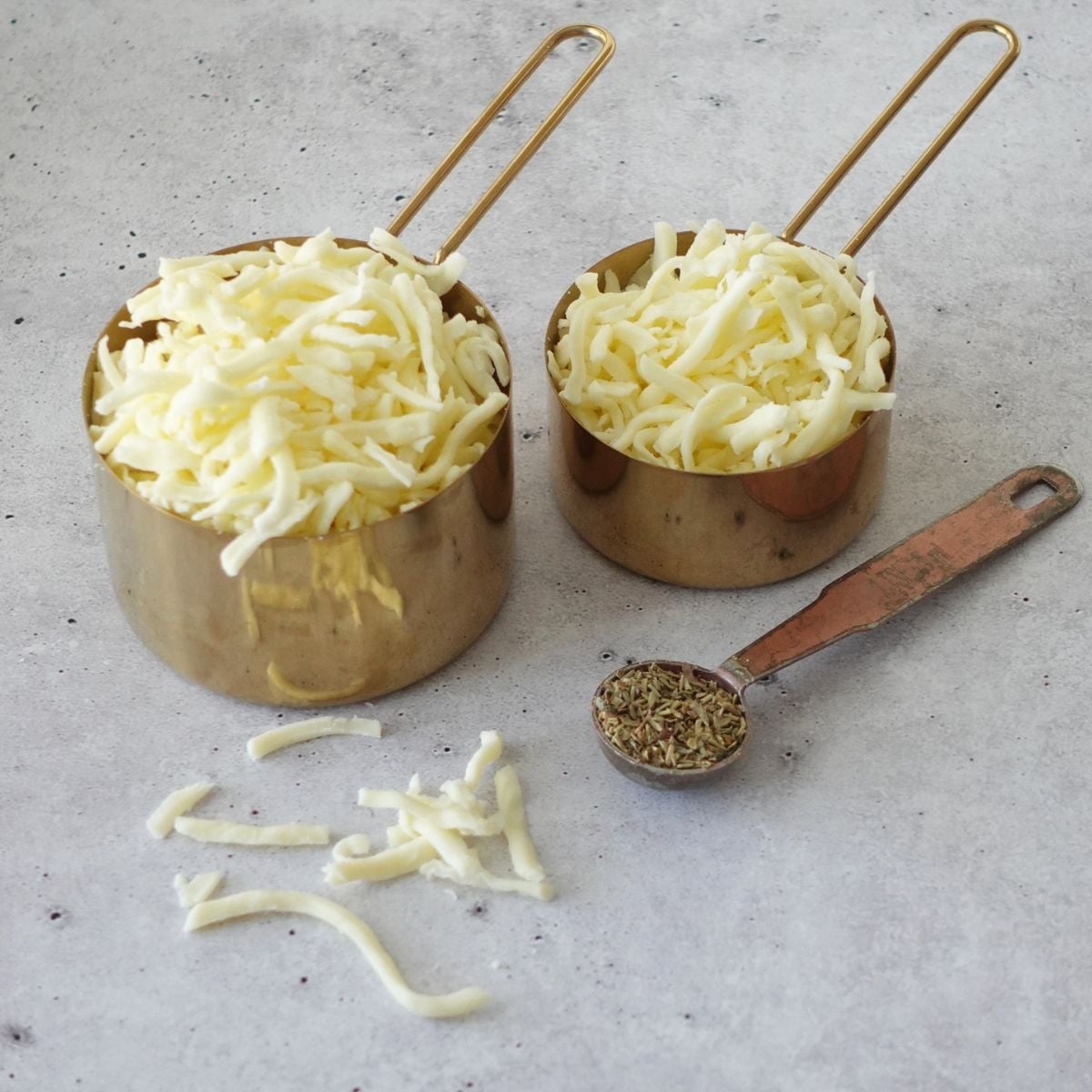Shredded mozzarella cheese and dried Italian herbs for focaccia topping