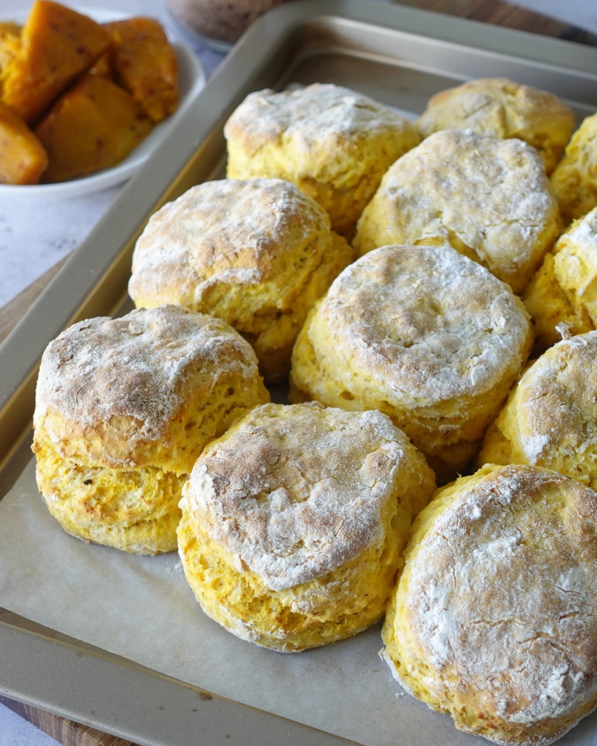 Baked peri peri pumpkin scones arranged touching on a baking tray