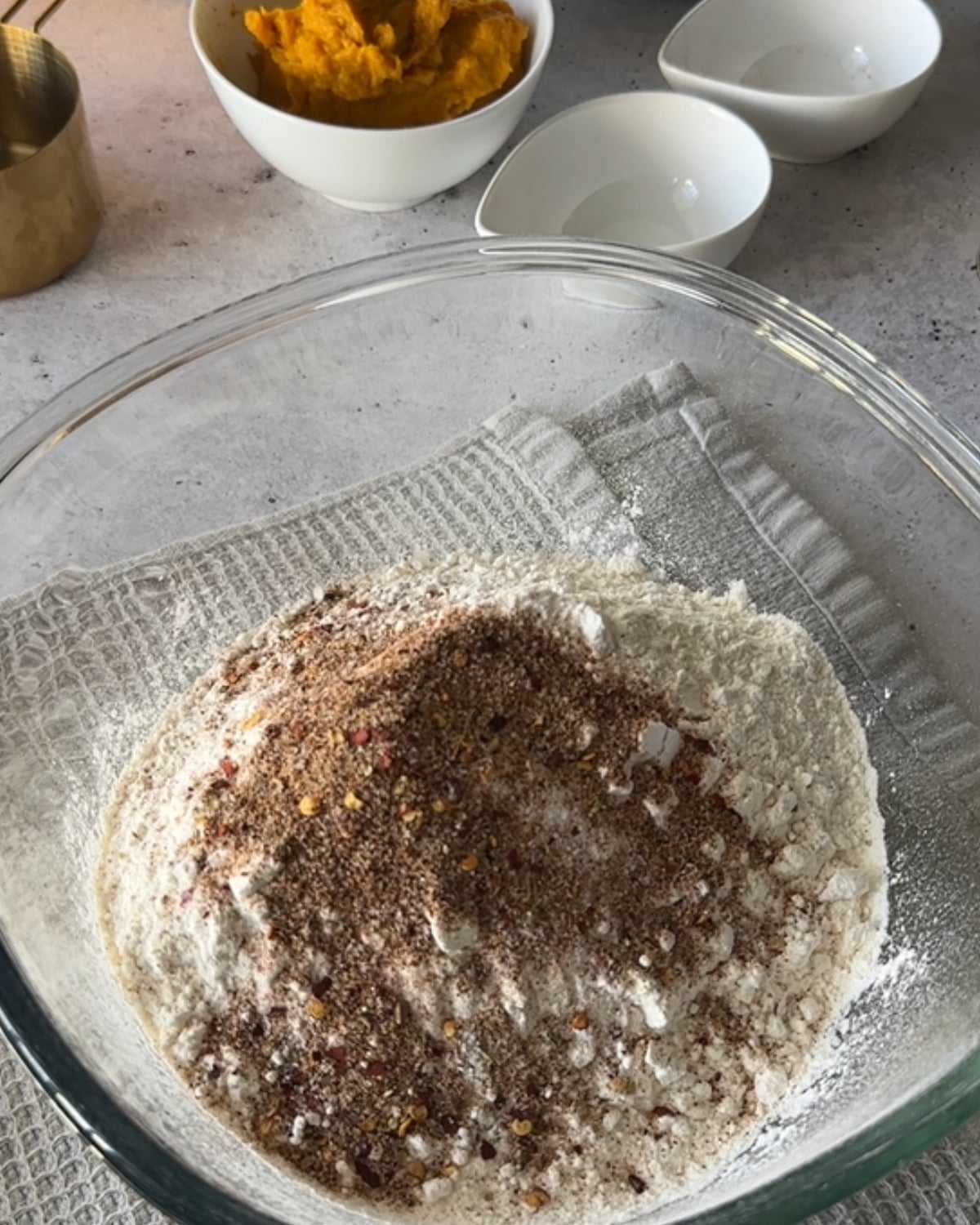 Self rising flour and peri peri spice blend in a glass bowl before whisking