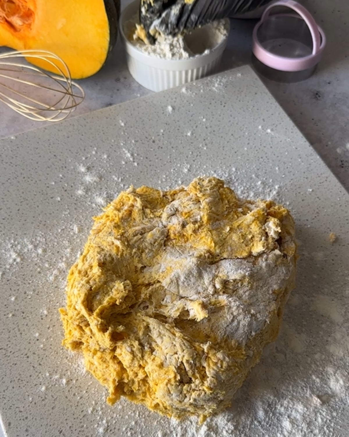 Hand kneading peri peri pumpkin scone dough briefly on a floured board