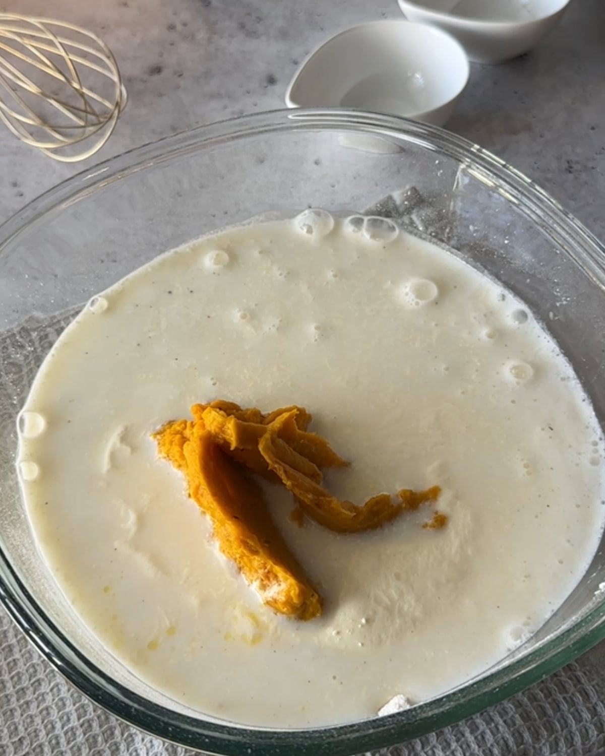 Silicone spatula mixing peri peri pumpkin scone dough in a glass bowl