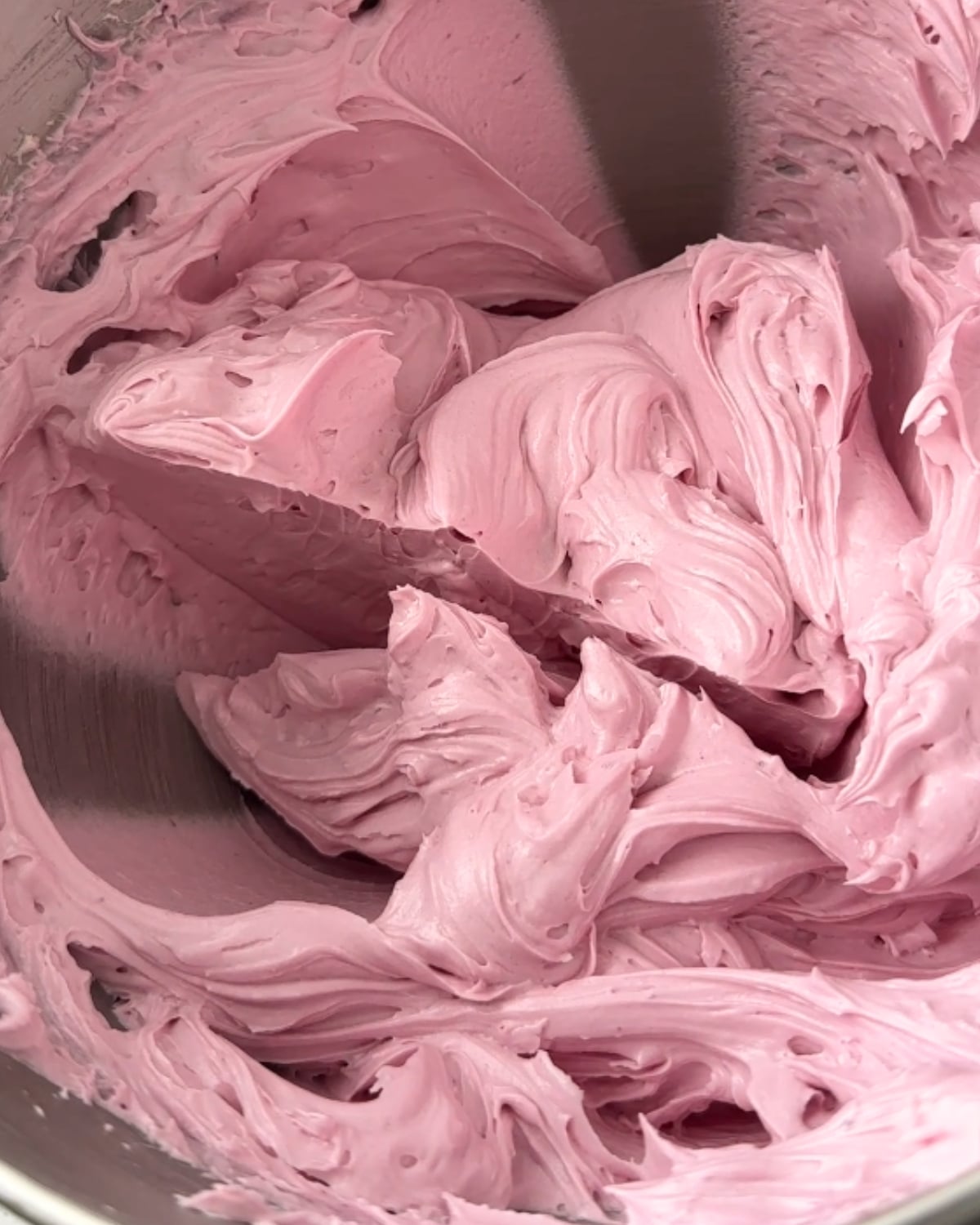 Finished ube hot water buttercream, smooth and purple, in a mixer bowl